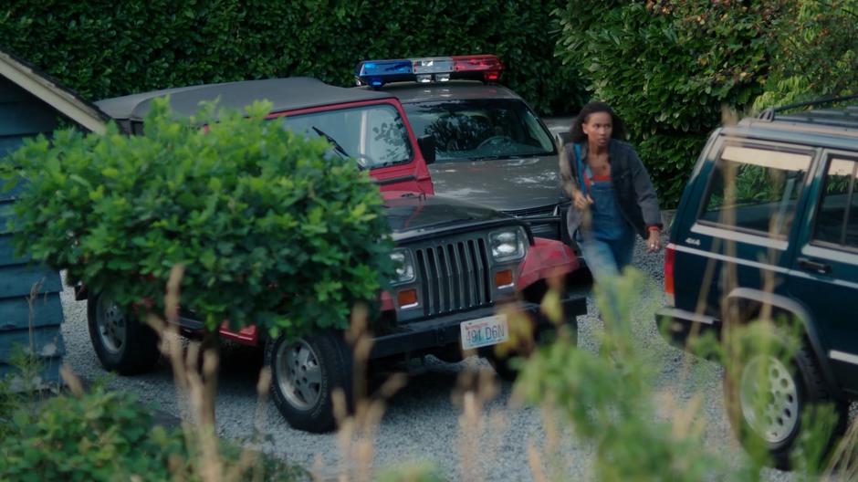 Maddie walks past several other parked cars up to the house.