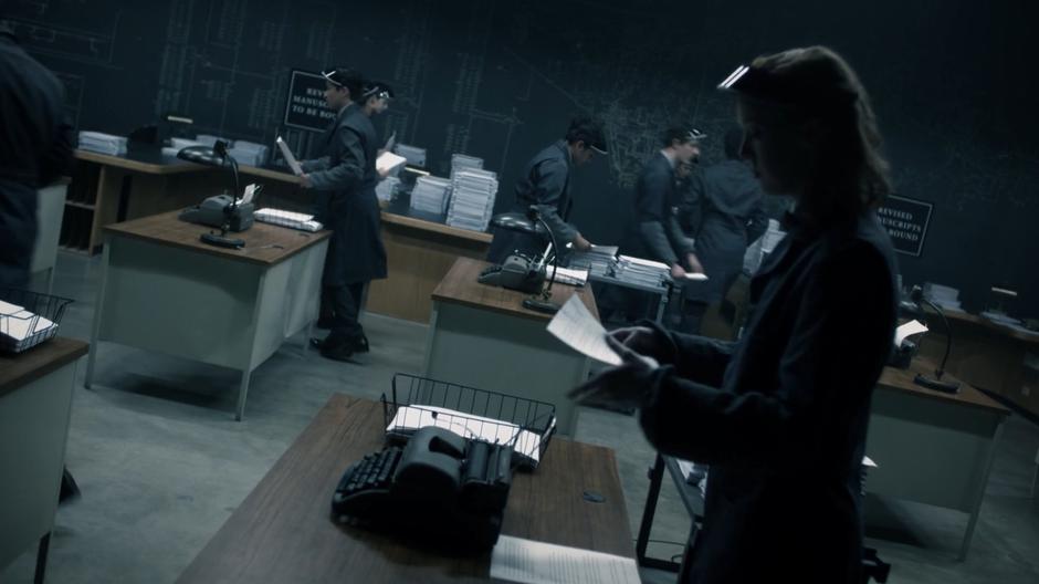 Workers in the revisions room work to assemble the books being put out by automatic typewriters.