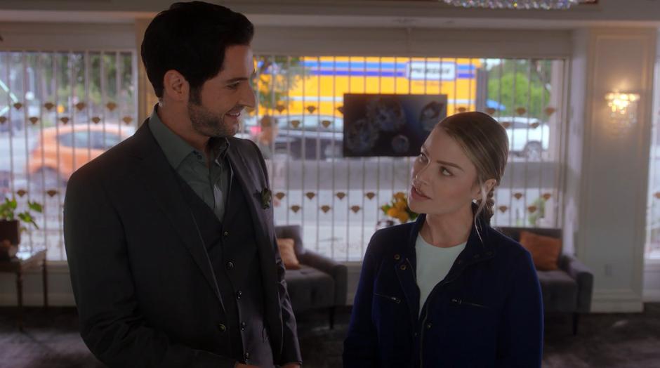 Lucifer and Chloe share a look while posing as a couple.
