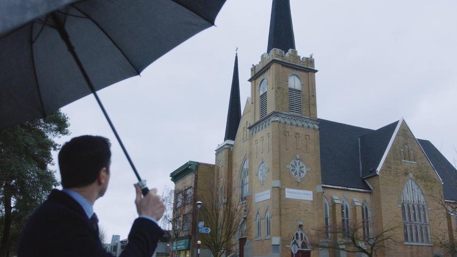 Harry turns around and looks up at a church.