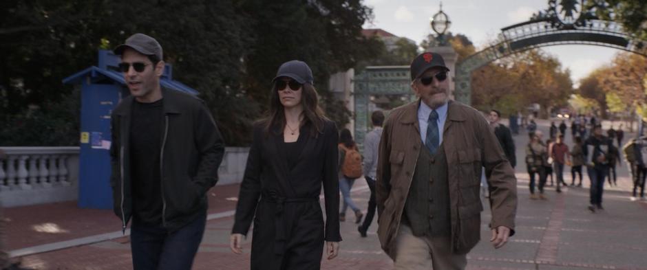 Scott, Hope, and Hank walk through the crowd while wearing hats and sunglasses.