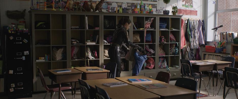 Hope hands Cassie's backpack down to tiny Scott.