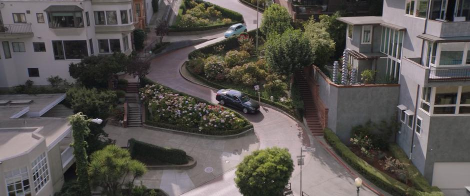 Two cars drive down Lombard Street.