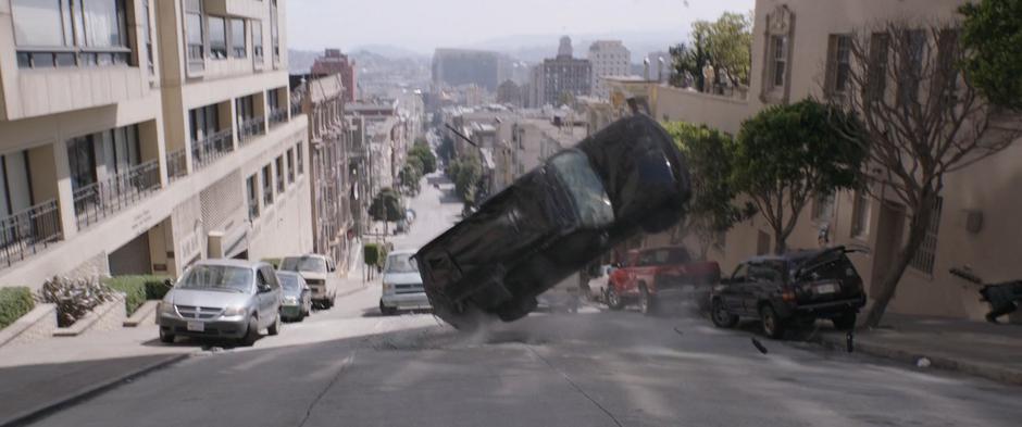The SUV flips side-over-side down the hill.