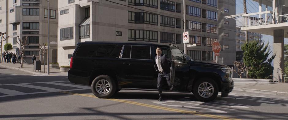 Agent Woo gets out of his SUV and looks up at the giant suit.