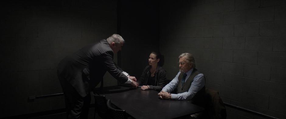 An agent cuffs Hope and Hank to the table in the interrogation room.