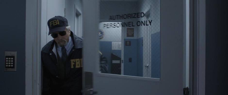 Hank walks out through the FBI office while dressed as an FBI agent.