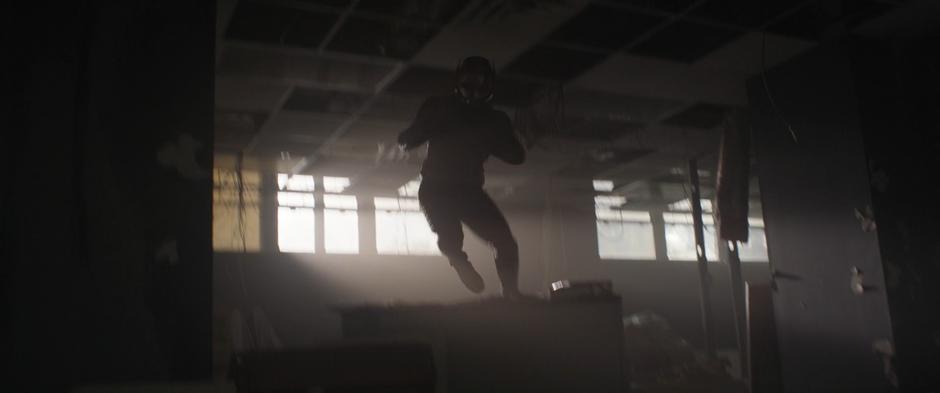 Scott jumps over a discarded desk while running from Ghost.