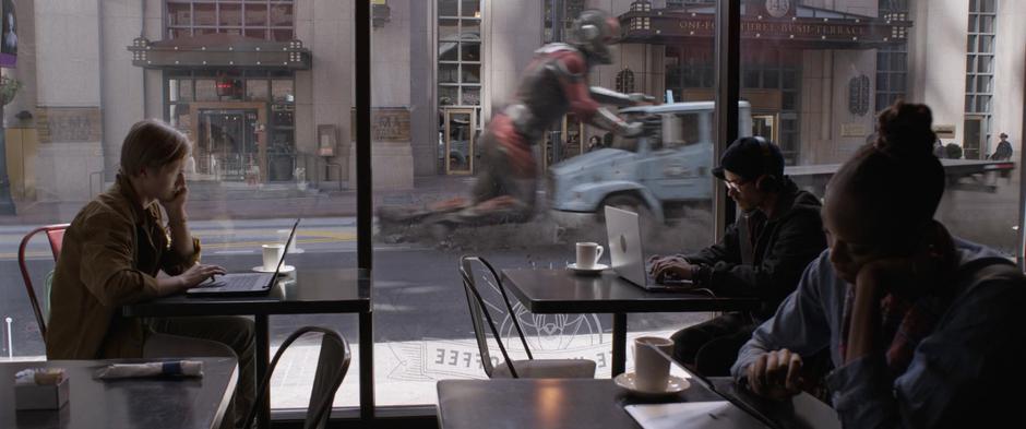 People work in a coffee shop while Scott grinds the truck to a stop outside the window.