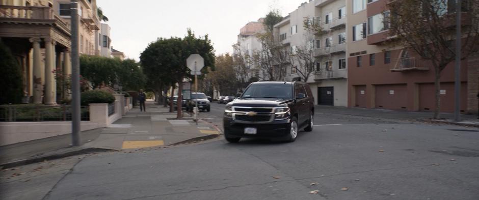 A FBI SUV turns the corner and heads down the hill.