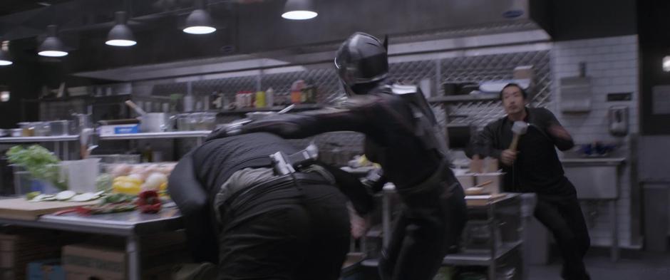 Hope fights with one of the goons in the kitchen while another approaches with a meat tenderizer.