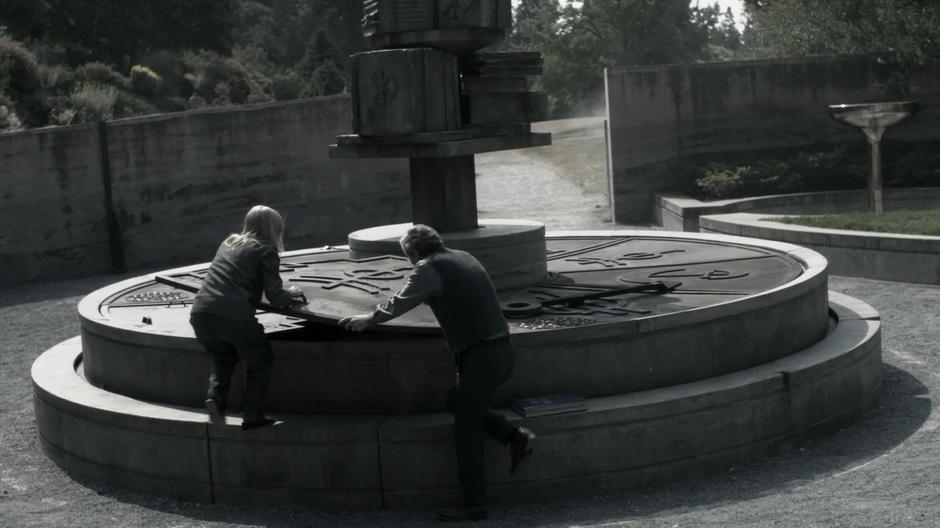 Alice and Christopher Plover work together to take the cover off the Poison Room fountain.