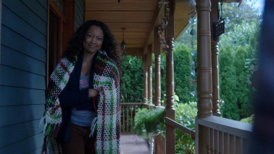 Susan smiles as Ryn and Maddie as they are talking on the porch.