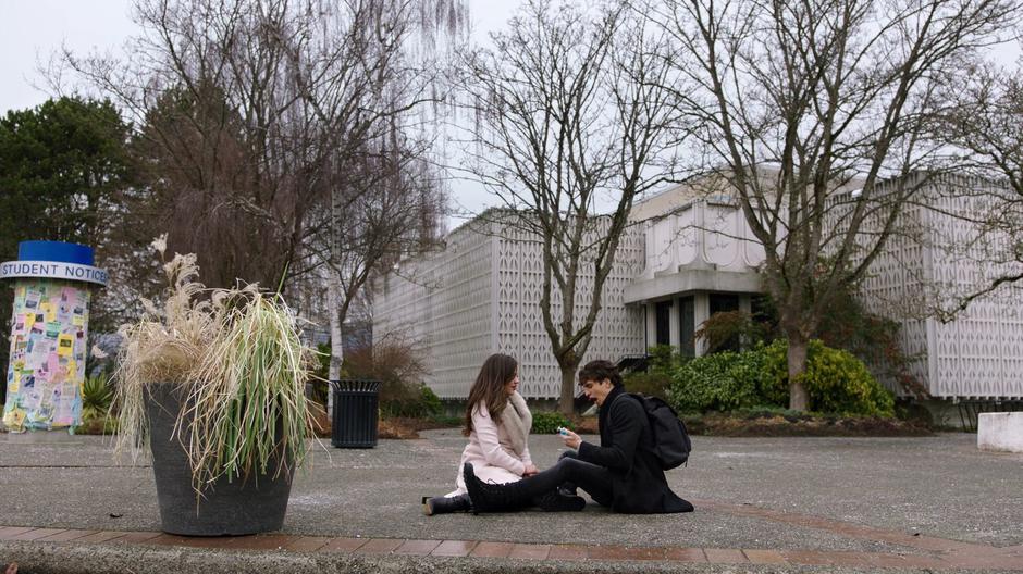 Parker looks down at the protection potion while sitting down on the sidewalk with Maggie after she saved his life.