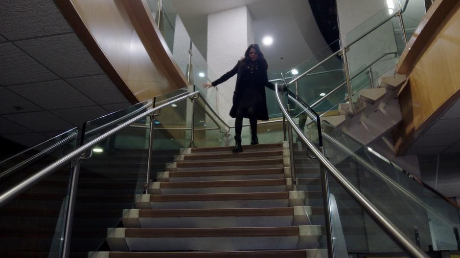 Mel runs down the stairs leading to the archive in her chase after Zack.