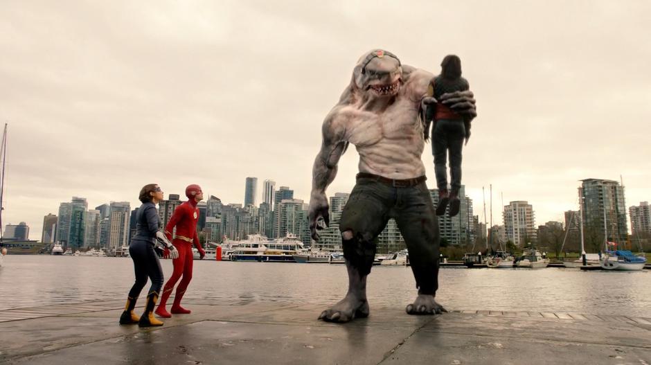 Nora and Barry watch as King Shark lifts Cisco into the air.