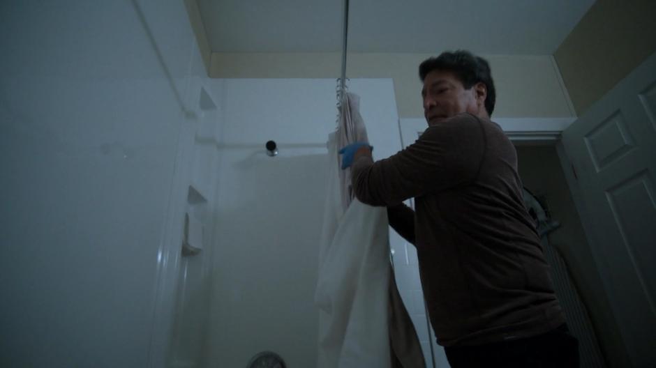 Dale pulls down the shower curtain to stage the crime scene.