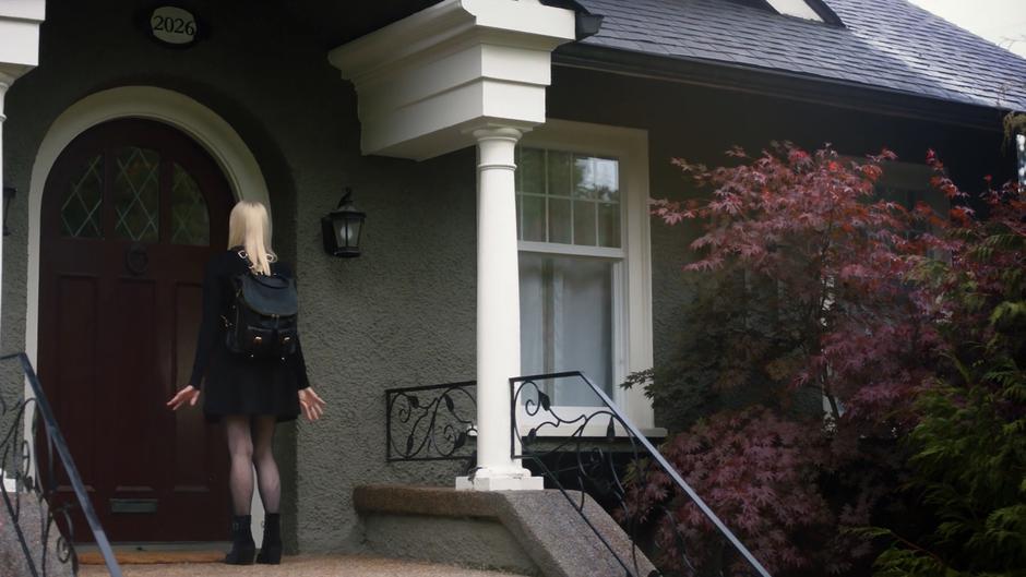 Alice stands outside the front door waiting for her mother to answer.