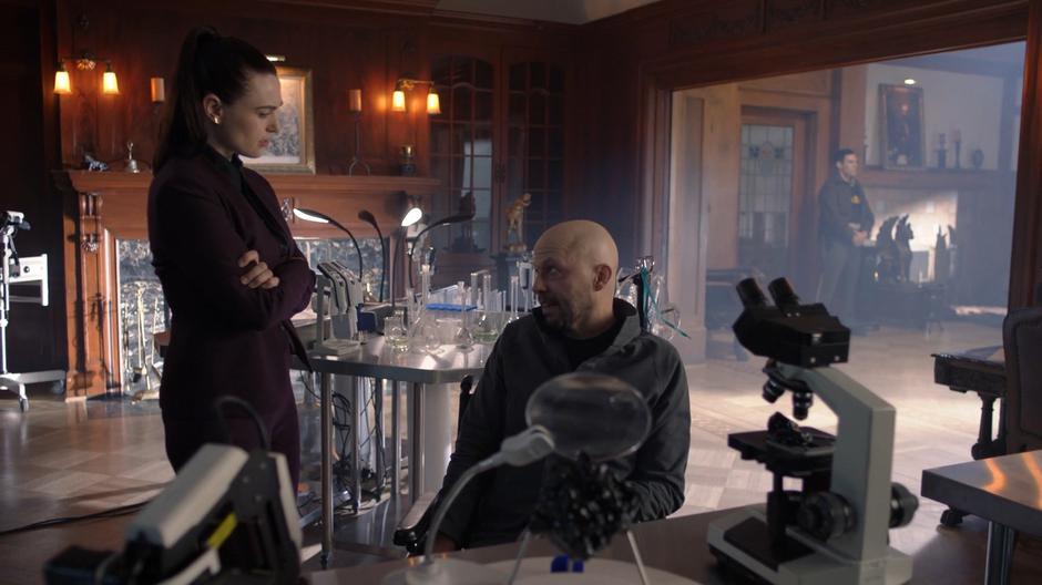 Lex talks to Lena while they work in the lab.