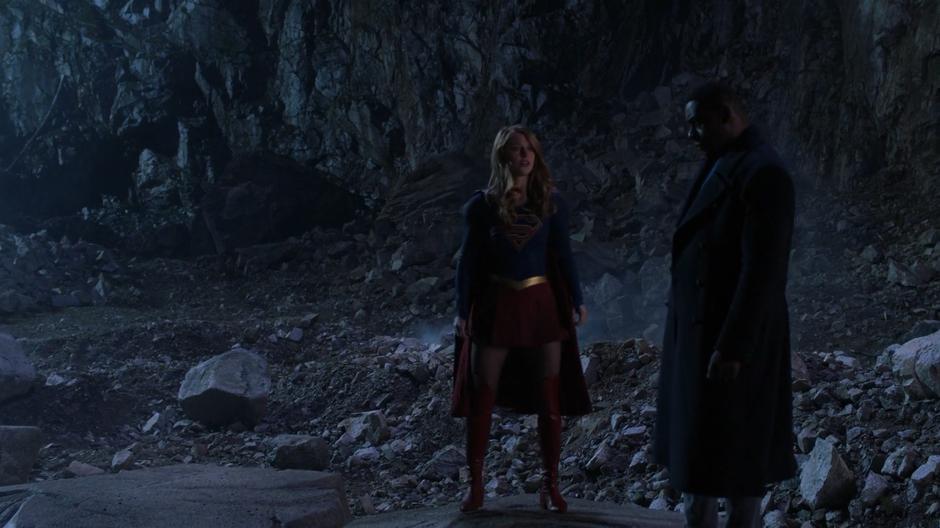 Kara lands down next to J'onn after Manchester and the wall of flames disappear.