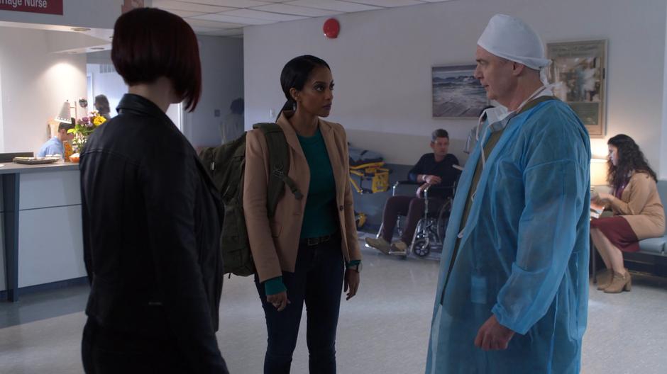 Alex looks at Kelly as she talks to the doctor about her brother.