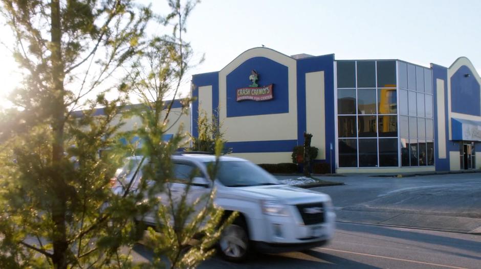 A car drives past on the street outside the family fun center.