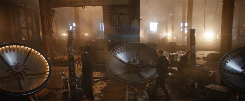 Members of the Discovery's crew work to set up the trap in the abandoned building.