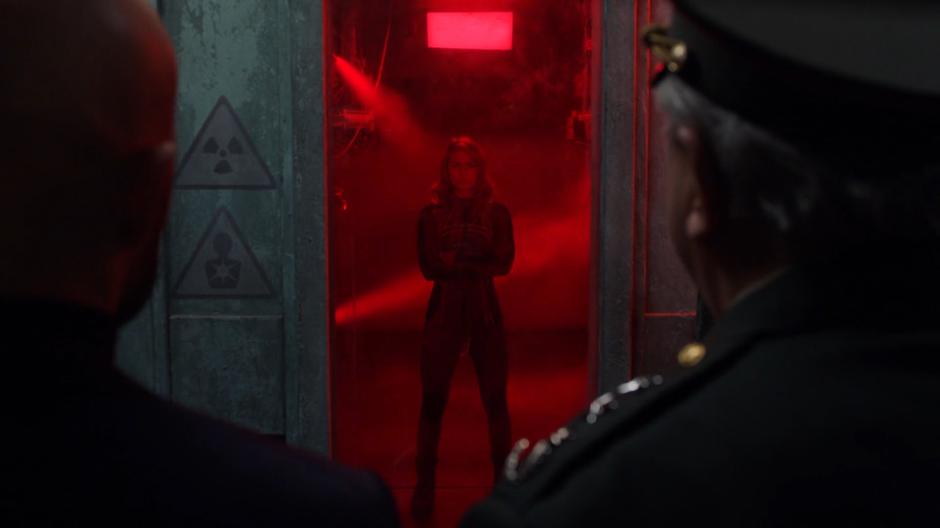 Lex and the Minister of Defense watch as Snowbird is tested in the radiation chamber.