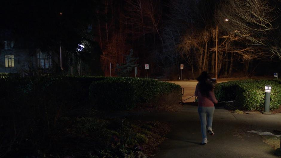 Scarlet runs down the path towards Niko's apartment building.