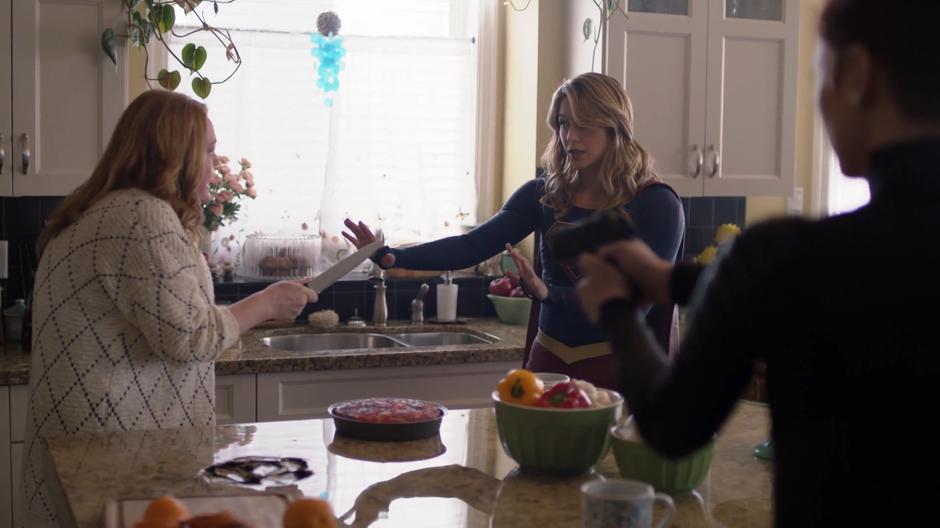 Kara tries to talk a knife wielding Bitsie Teschmacher down while Alex holds her gun ready.