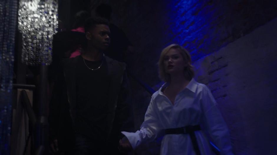 Tyrone and Tandy walk down the steps into the club holding hands.