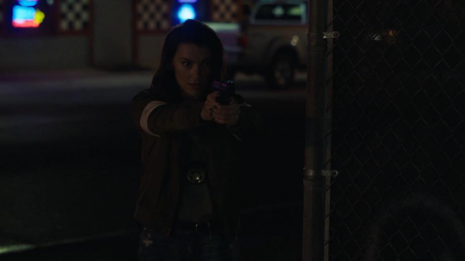 O'Reilly holds her gun out as she comes around the corner and sees Tandy.