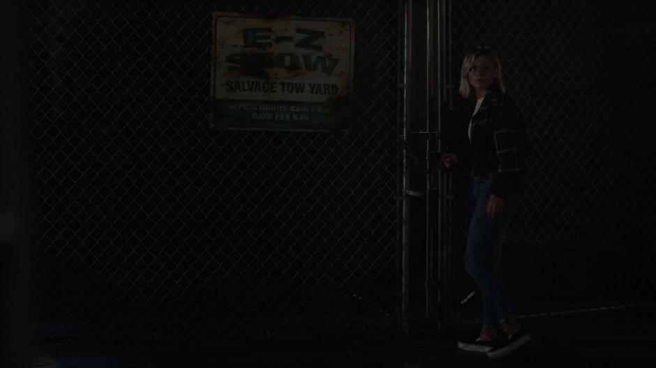 Tandy turns around from where she was examining the lock on the gate.