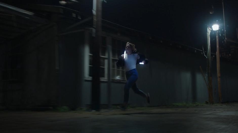 Tandy chases after the ambulance driver with her two light daggers in hand.