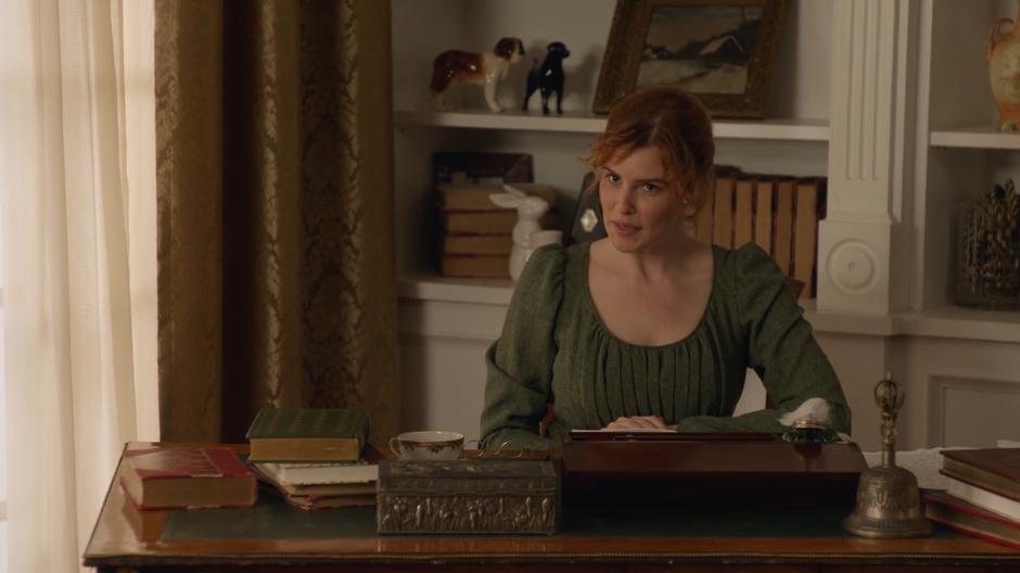 Jane Austen looks up from her writing desk as Mona and Sara are introduced.