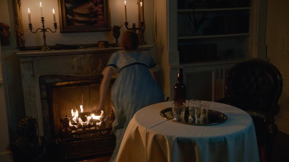 Jane Austen grabs a poker from beside the fireplace.