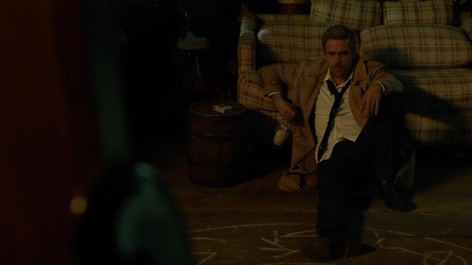 Constantine sits on the floor with a bottle of booze and talks to the Neron in the mirror.