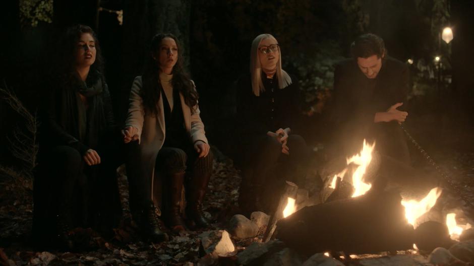 Kady, Julia, Alice, and Eliot sing *Take On Me* around the fire while remembering Quentin.