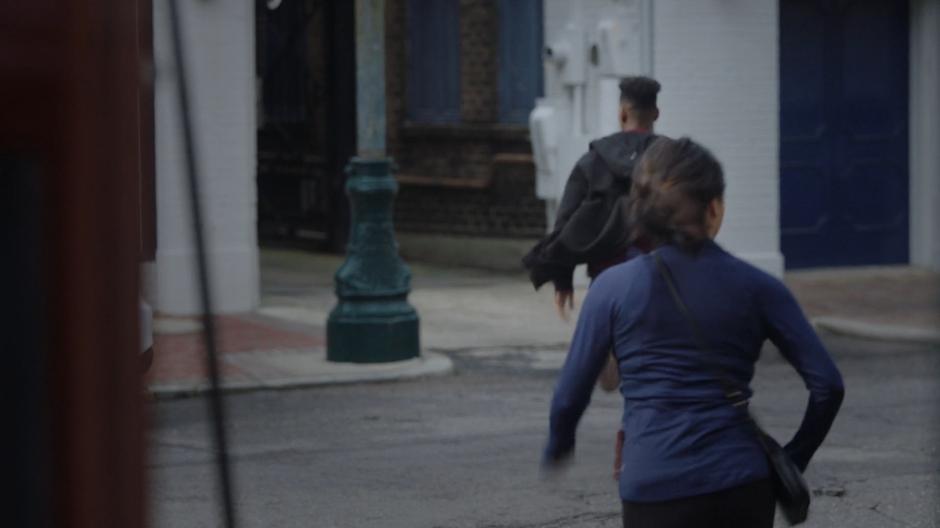 Tyrone leads Adina across the street and into an alley.