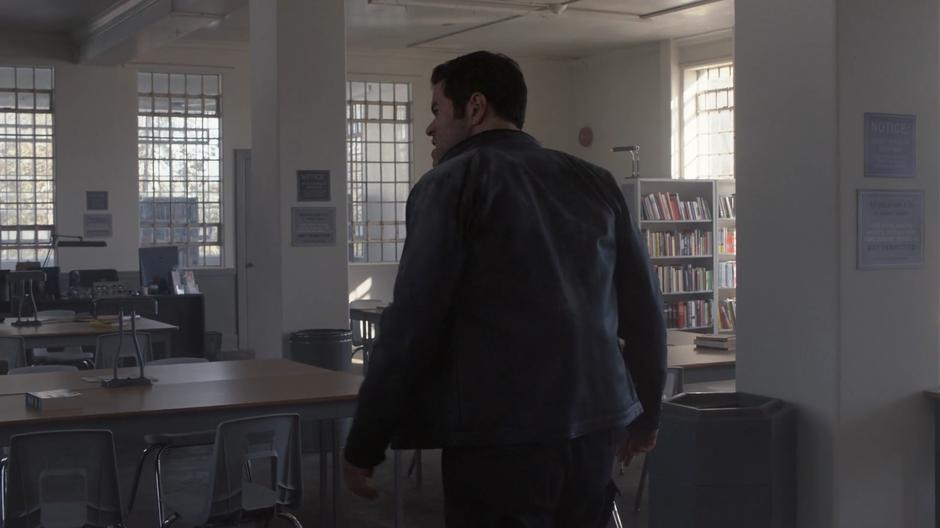 Otis Graves searches around the prison library for Supergirl.