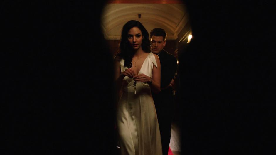 Nate follows Zari as she approaches the vault door with the key stolen from the guard.