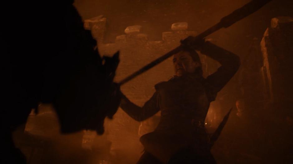 Arya fights the dead on the wall of the castle.