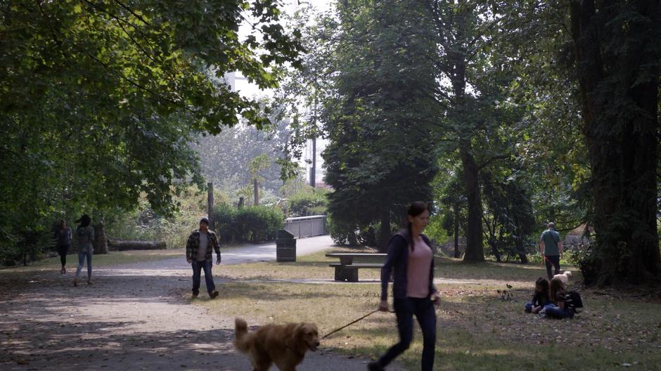 Baron walks through a busy park looking for Oliver.