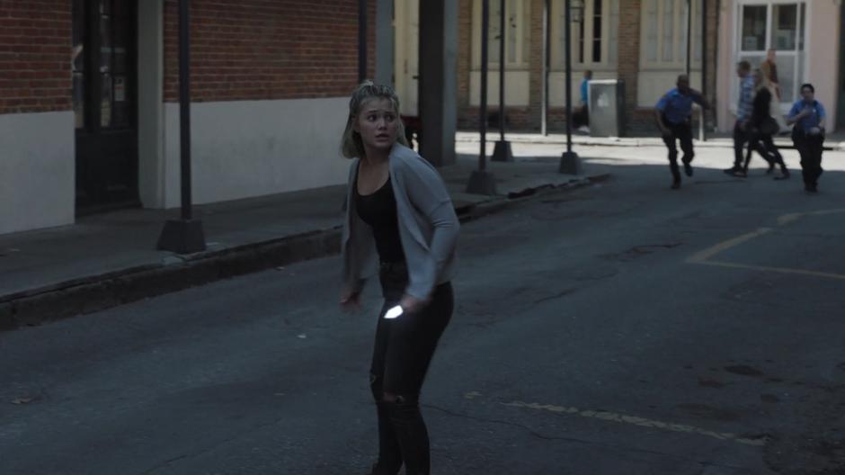 Tandy searches for a way to escape the police while holding her light dagger in the middle of the street.
