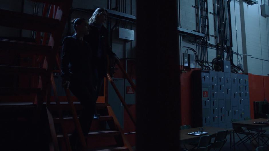 Lena and Kara descend the steps into the secret laboratory.