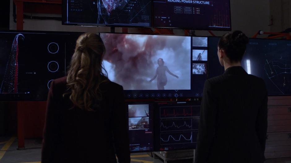 Kara and Lena watch footage of Red Daughter being tested.
