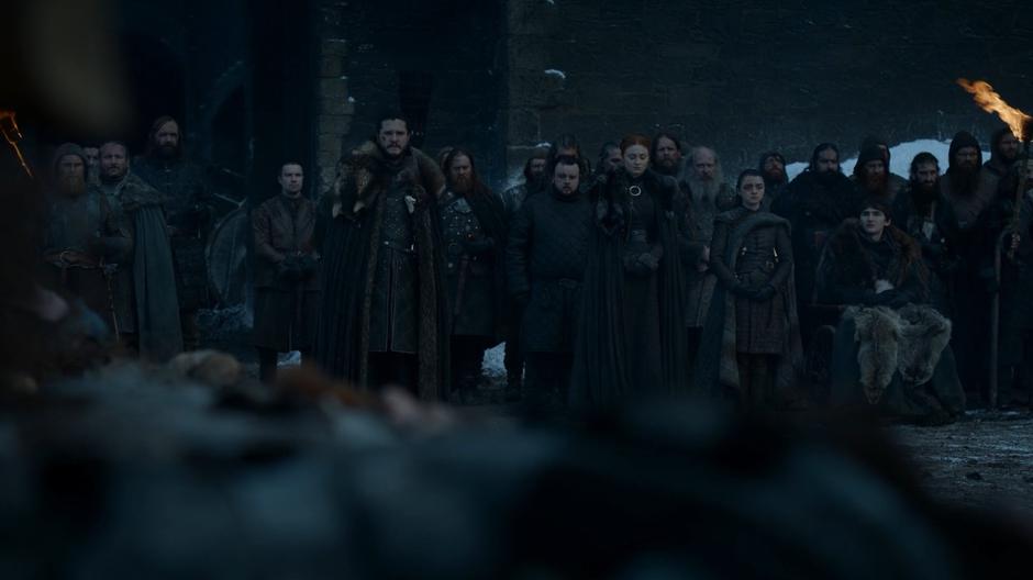 The survivors of the Battle of Winterfell line up in front of the castle as Jon gives a speech honoring the dead.