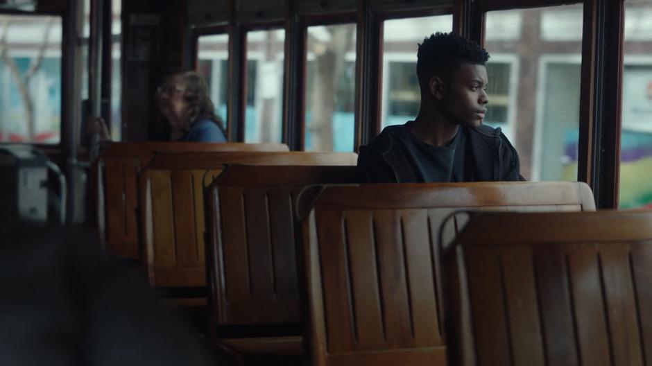 Tyrone looks out the window while riding in the streetcar.