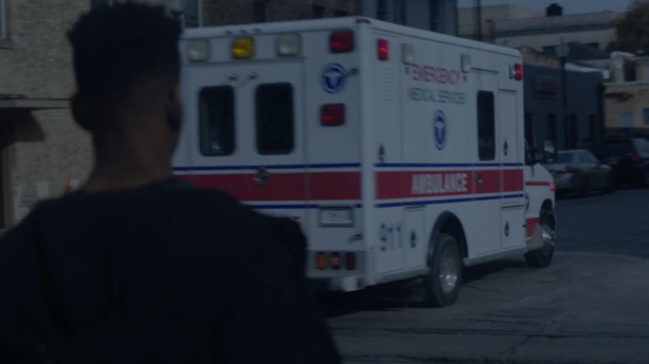 Tyrone watches as several identical ambulances drive past in multiple directions.