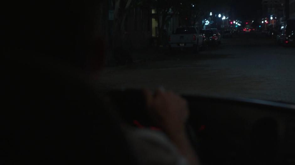 The ambulance driver head down a street at night.